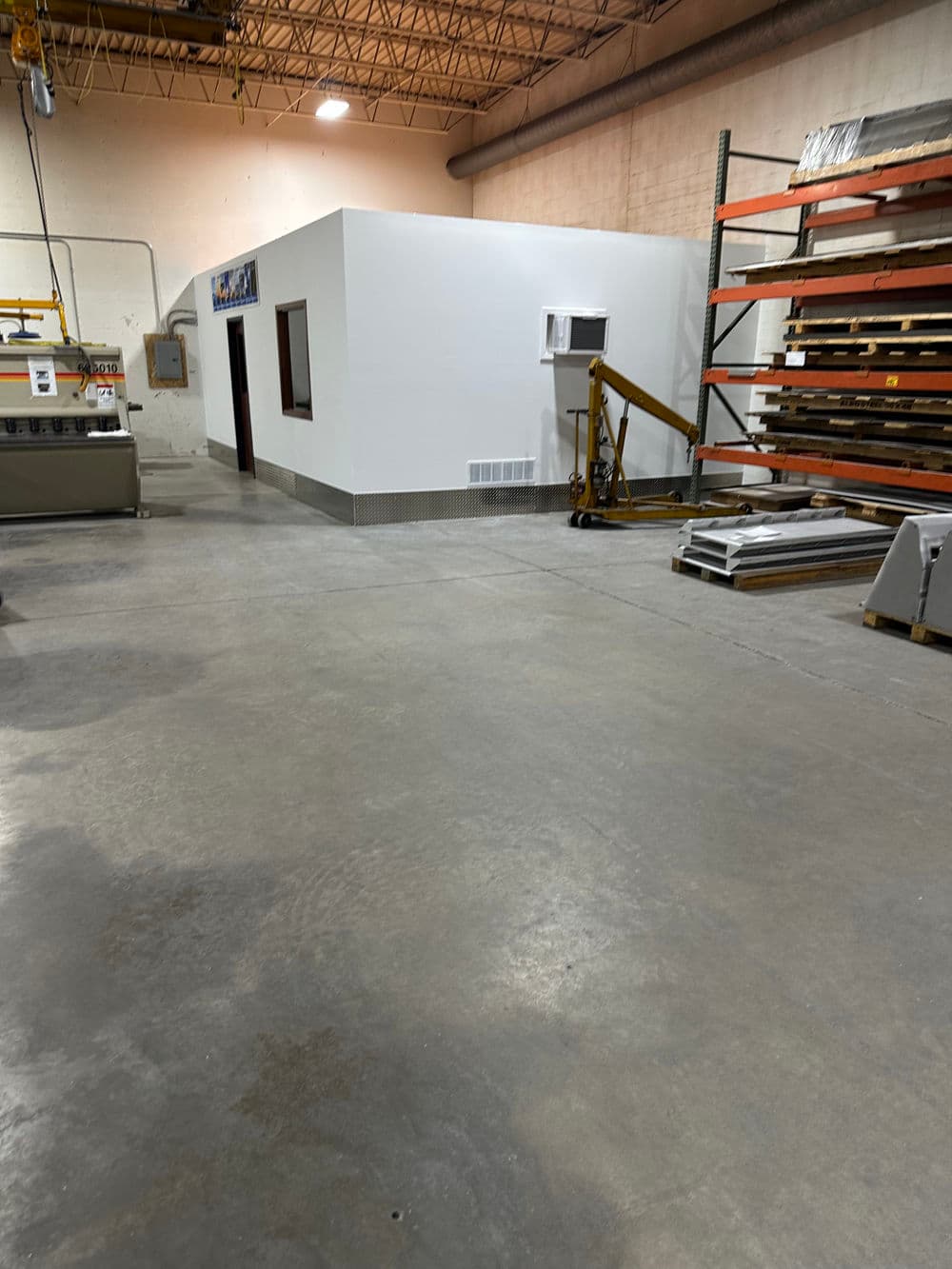 Interior of a warehouse featuring a storage area, walls, and equipment.