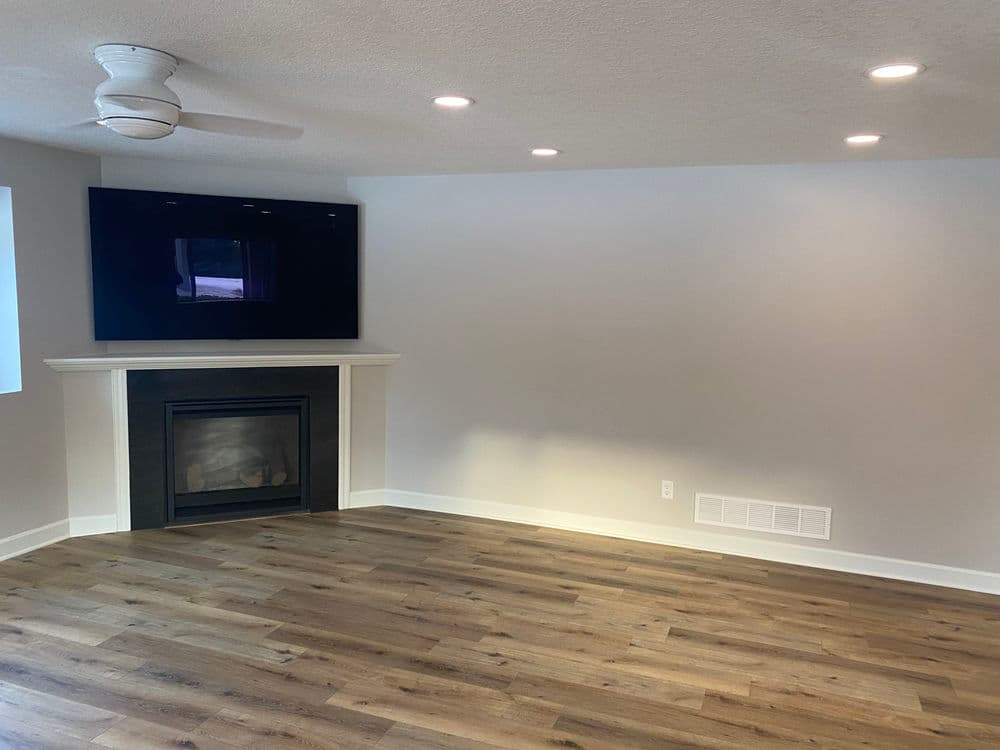 Cozy living room with modern fireplace, light hardwood floors, and flat-screen TV.