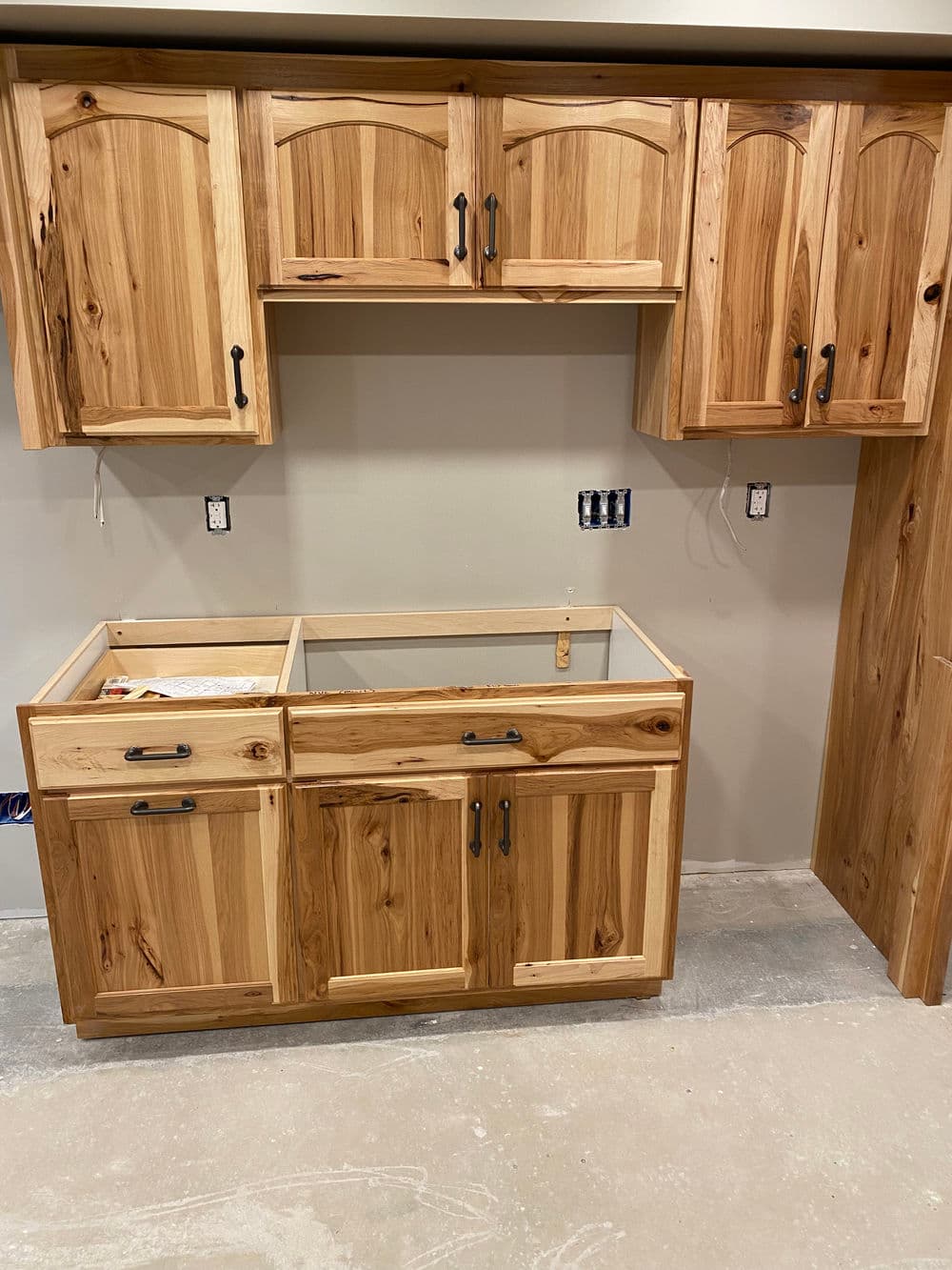 Modern rustic kitchen cabinetry with wood grain details, featuring upper and lower cabinets.