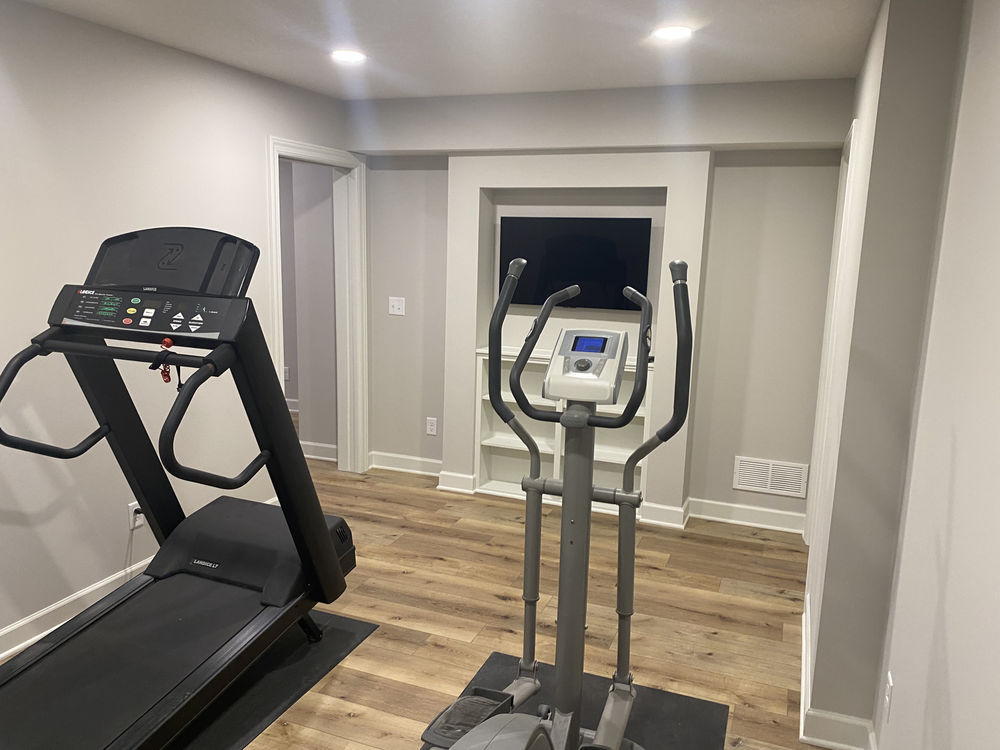 Home gym setup featuring a treadmill and elliptical machine in a modern space.