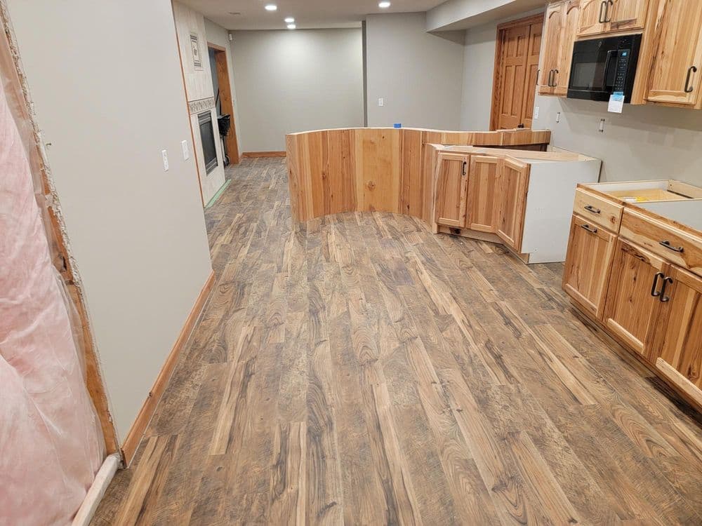 Remodeled kitchen featuring wooden cabinets and new flooring, with an open layout.