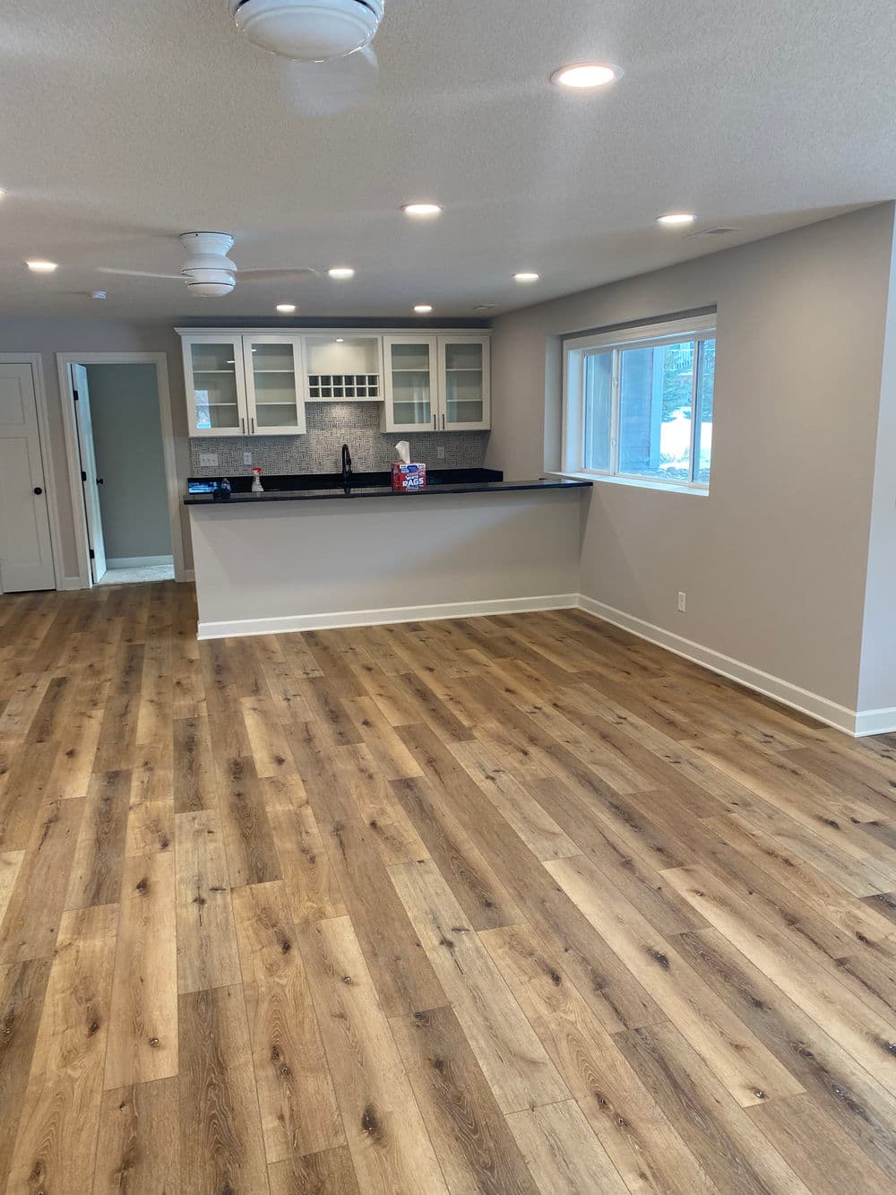 Spacious modern living room with hardwood floors and open kitchen layout.